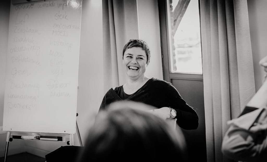 Petra lacht breed naast het whiteboard